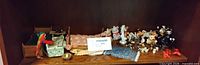 Shelf view showing wooden miniature beds, textiles and animal figurines