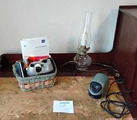 Overall lot showing basket with desk supplies, oil lamp and Logitech speaker