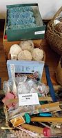 Overall lot showing yarn skeins, yarn balls, Quiltworx pattern box, knitting needles, crochet hooks, wooden crate and wicker basket