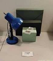 blue desk lamp, two green organizers, small box with lid
