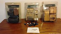 Overview of three packaged furniture sets and loose blue accessories