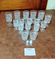 Group shot of all clear pressed glass goblets, tumblers, and salt & pepper shakers arranged on table