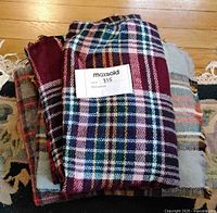 Stack of plaid wool items showing patterns and textures