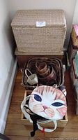 Lot overview showing wicker chest, basket, wooden crate with fabric bags