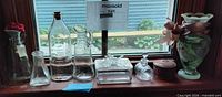 Full lot on windowsill showing all glass pieces and metal tin