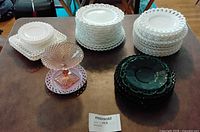 Overall lot with stacks of milk glass plates, green plates and pink compote