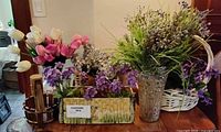 Group shot of artificial flowers in containers on table