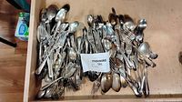 Drawer full of mixed flatware pieces