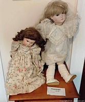 Front view of both dolls on small table showing outfits and scale