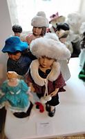 Group showing both porcelain dolls among others on table