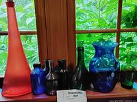 Seven assorted vintage blown glass pieces on windowsill showing color, shape and condition