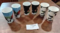 All six tall ceramic mugs displayed upright showing the three distinct designs