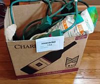Box holding two packaged Simply Conserve power strips and loose green surge protectors