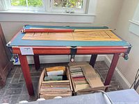 Overall view of multi-game table with cues resting on surface