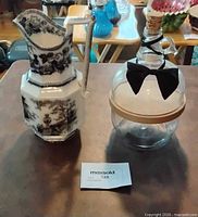 Pitcher and decanter standing side by side
