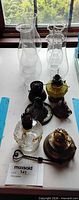 Lot overview showing three glass chimneys and assorted lamp parts