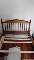 Headboard with spindle design, side rails and partial slats visible