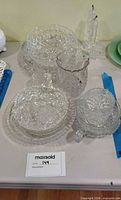 Group shot of assorted clear cut and pressed glass pieces stacked together