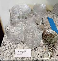 Group shot: stacked plates and bowls, candlesticks, pitcher, silver lattice scoop