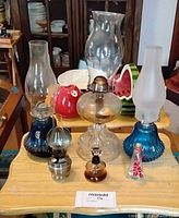 Group shot showing all six lamps with various chimneys and bases