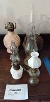 Front view showing assembled small lamps, pink ribbed font, tall chimney, flared shade, brass parts