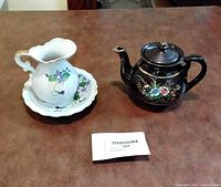 Group view of teapot with lid, creamer and saucer
