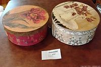 Two decorative hat boxes side by side, lids visible