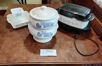 Group shot of electric roaster, stackable round blue floral casseroles, rectangular turquoise casseroles, small glass dish