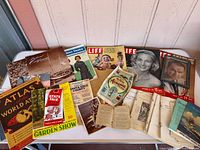 Overall view of magazines, atlas, programs and brochures on table