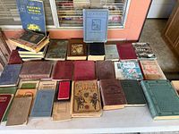 Overview of entire lot of antique books spread on table