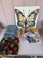 Overall lot with fabrics, sewing notions and butterfly panel