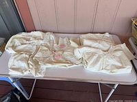 Three folded antique nightgowns on table
