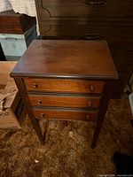 full view of cabinet showing three drawers, legs, top surface