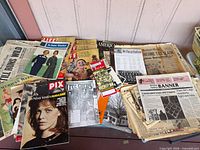 Table covered with assorted magazines and newspapers
