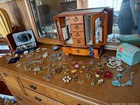 Overall view of armoire, boxes and spread of costume jewelry on dresser