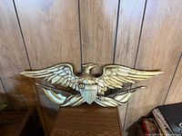 Front view of gold-tone eagle plaque showing full design