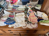 Overview of assorted doilies and crocheted items on dresser