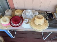 Overall view of seven hats and two handbags on table