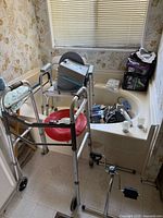 Overall view showing walker, commode chair, raised seat, supplies