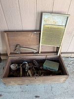 Overall view of chest, washboard, axe, lunchbox and visible hand planes