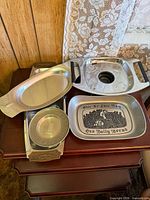 Group view of six metal serving pieces on table