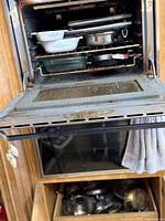 Overall view of oven with cookware and drawer containing stainless pots