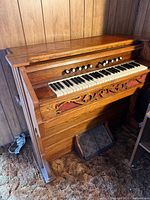 Front view showing keyboard, stop knobs and carved panel