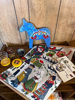 Group shot showing Dala horse, towels, cups, coasters, napkin ring, booklets