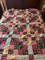 Side A of quilt laid flat on bed showing patchwork fabrics