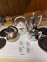 Four pots and kettles on stovetop