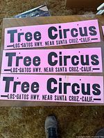 Three of the six identical pink Tree Circus advertising signs displayed flat to show text, color and condition