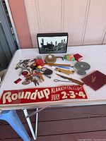 Overview of entire lot on table including sign, photograph, trinkets, autograph book