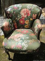 Front view of floral upholstered armchair showing fabric pattern, wood frame and general condition