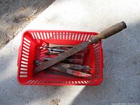 Red basket holding multiple Fuller screwdrivers and one Black Diamond chisel